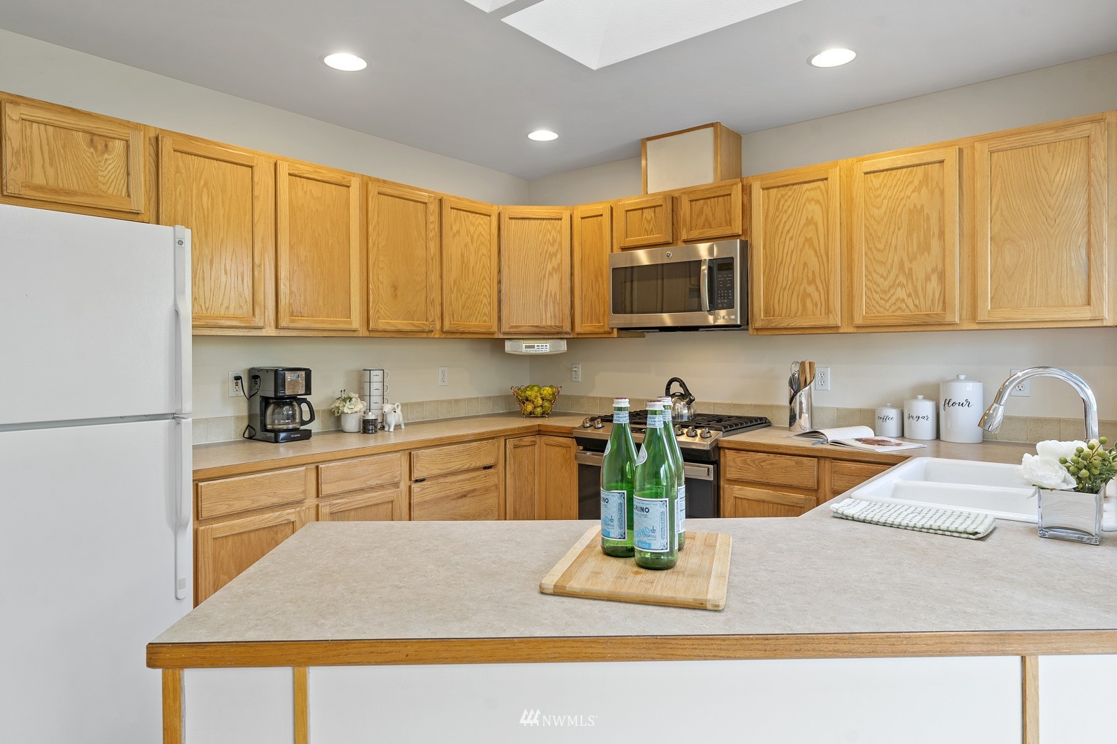7 167th Place Southwest Bothell, WA 98012 - Photo 8 of 30 a kitchen with stainless steel appliances granite countertop a refrigerator a stove top oven a sink dishwasher and cabinets with wooden floor