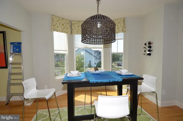 a dining room with furniture a chandelier and wooden floor