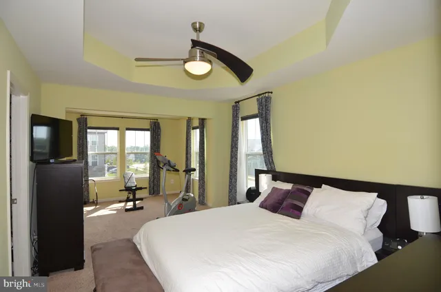 a bedroom with a bed and large windows