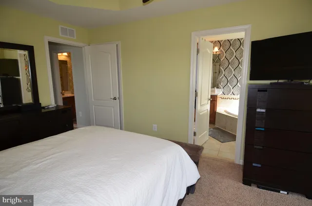 a bedroom with a bed and a flat tv screen on wall