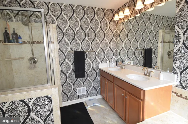 a bathroom with a sink and mirror with shower