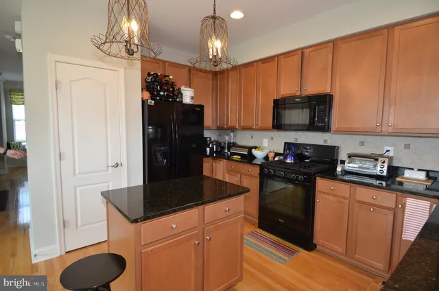 a kitchen with granite countertop a refrigerator stove and sink
