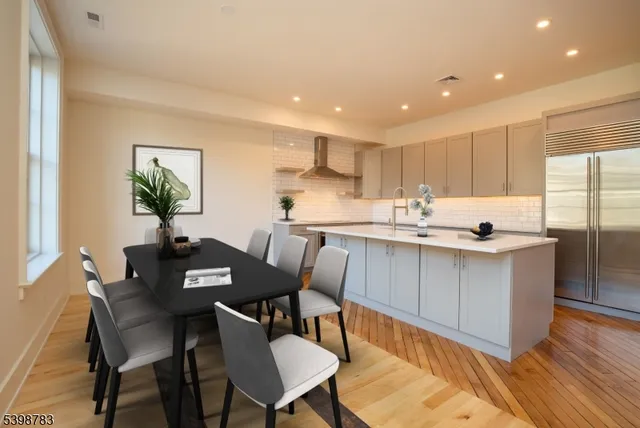 a kitchen with a dining table chairs and wooden floor