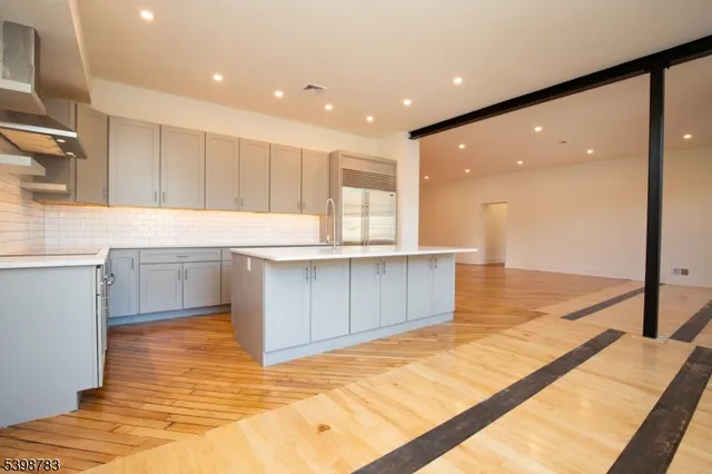 a large kitchen with stainless steel appliances a large counter top a stove and a sink