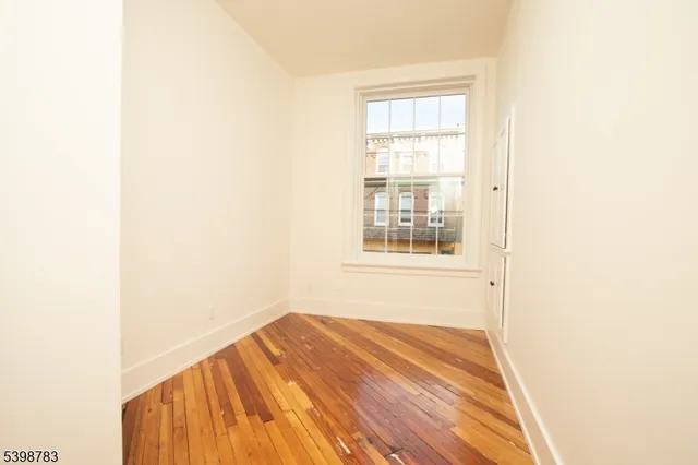 a view of a room with wooden floor and a window