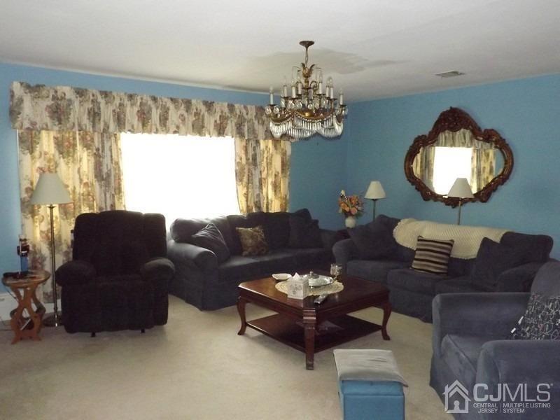 3 Butcher Road Monroe Township, NJ 08831 - Photo 2 of 11 a living room with furniture chandelier and a window