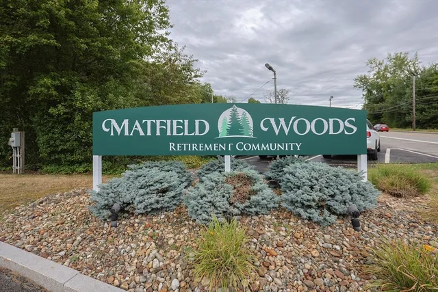 a sign broad in front of a red brick house