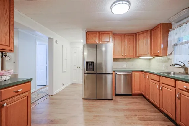 a kitchen with stainless steel appliances granite countertop a refrigerator sink and cabinets