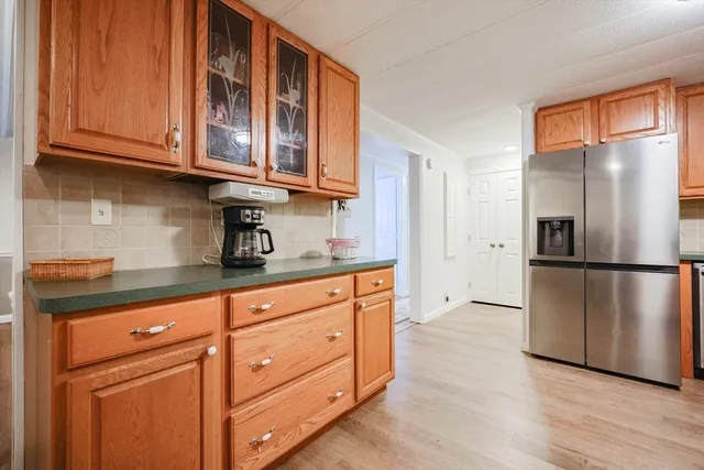 a kitchen with stainless steel appliances granite countertop a refrigerator microwave and cabinets