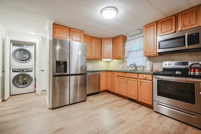 a kitchen with stainless steel appliances granite countertop a refrigerator a stove top oven a sink and dishwasher