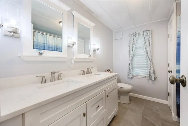 a bathroom with a sink a toilet and a mirror