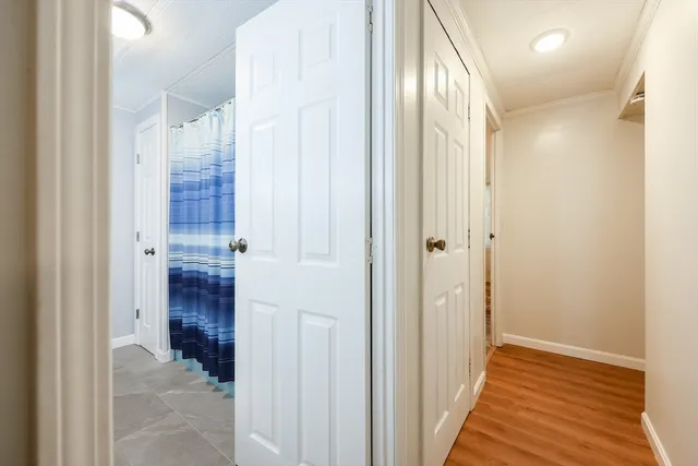 a view of a hallway with wooden floor and staircase