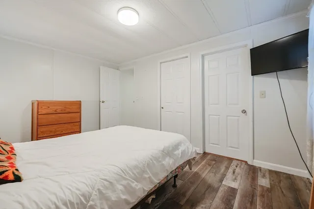 a bedroom with a bed and a flat tv screen on a dresser