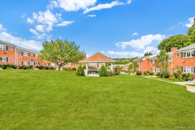 a view of a house with a big yard and a large tree