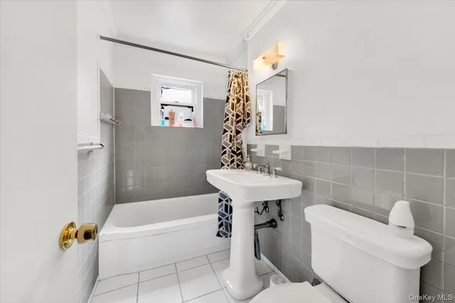 a bathroom with a sink a toilet a mirror and bathtub