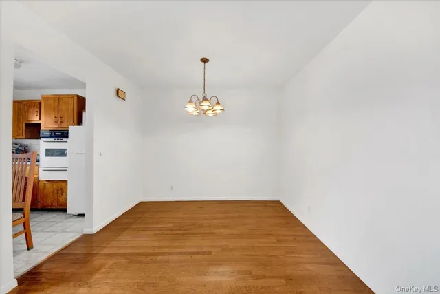 a view of empty room with wooden floor and window