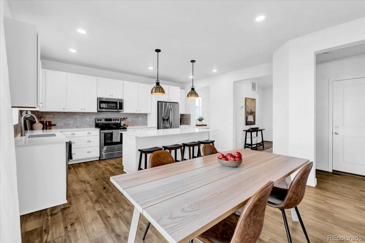 5453 Inland Avenue Firestone, CO 80504 - Photo 12 of 49 a kitchen with stainless steel appliances granite countertop a kitchen island hardwood floor sink and stove