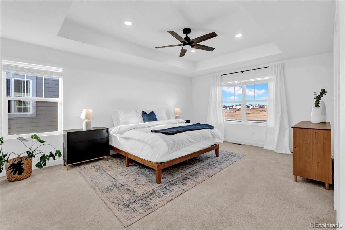 5453 Inland Avenue Firestone, CO 80504 - Photo 22 of 49 a bedroom with a bed and a chandelier
