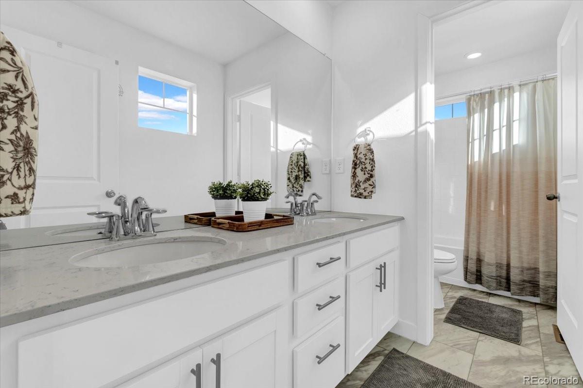 5453 Inland Avenue Firestone, CO 80504 - Photo 26 of 49 a bathroom with a double vanity sink and a mirror