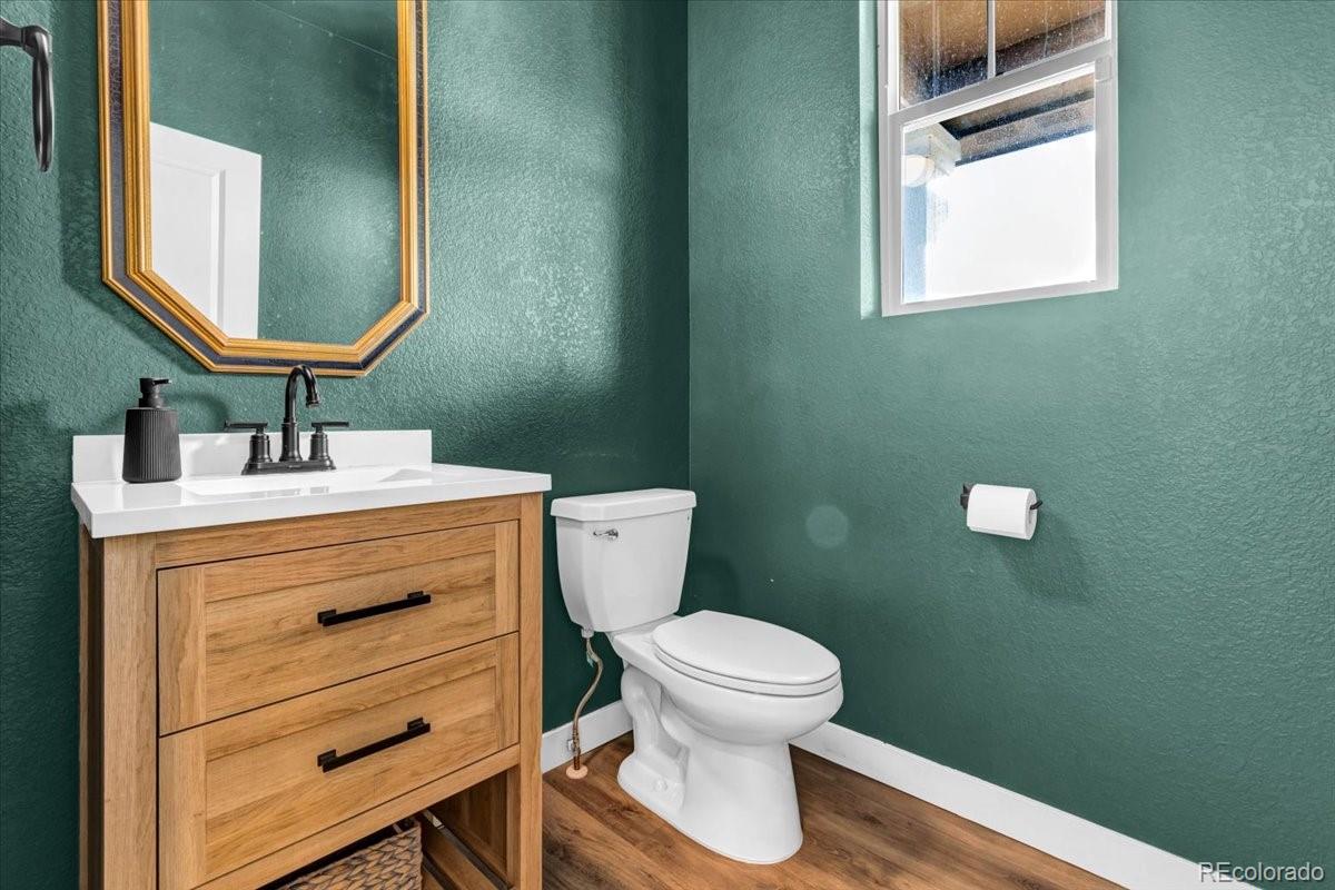 5453 Inland Avenue Firestone, CO 80504 - Photo 31 of 49 a bathroom with a toilet sink vanity and mirror