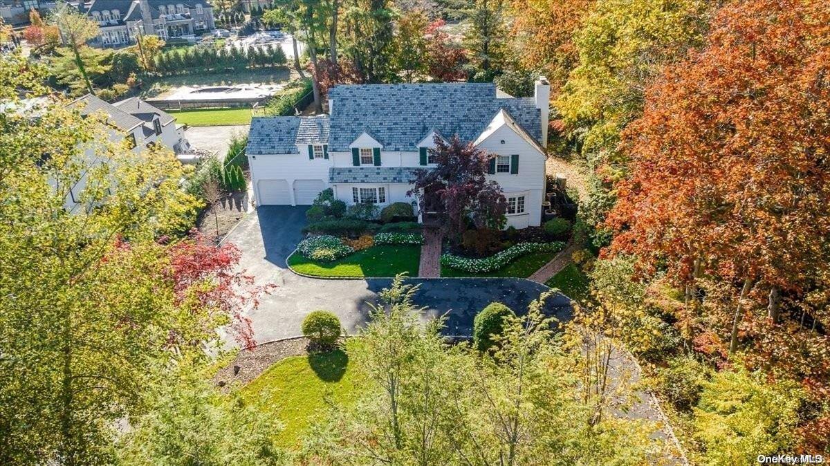 a aerial view of a house with swimming pool and large trees