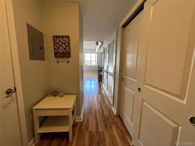 a view of a hallway with wooden floor and a bathroom