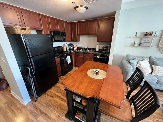 a kitchen with stainless steel appliances wooden floor dining table and chairs