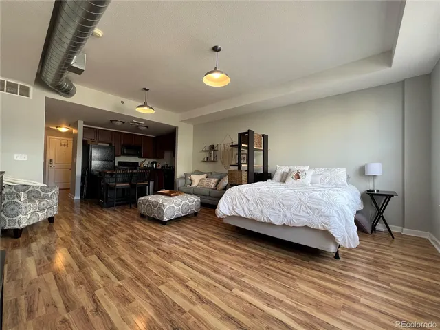 a bedroom with furniture and a wooden floor