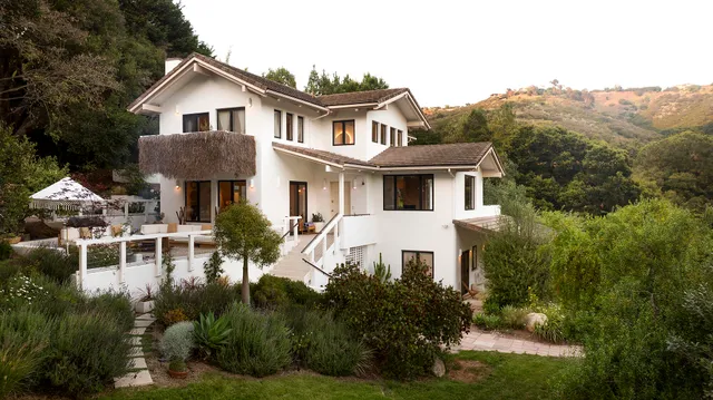 a front view of a house with a yard and lake view