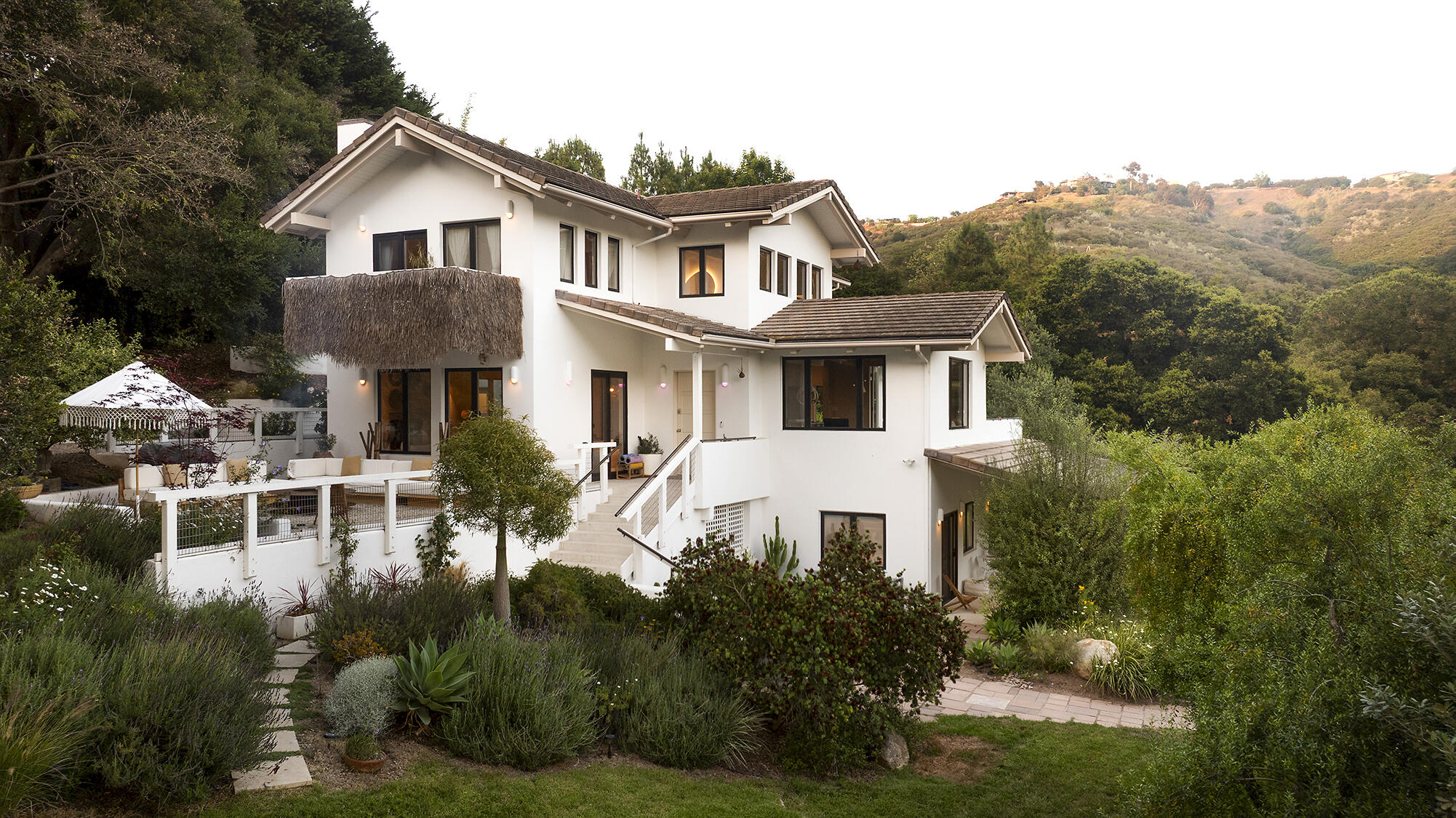 a front view of a house with a yard and lake view