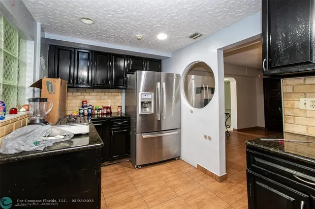 a kitchen with a refrigerator and a stove