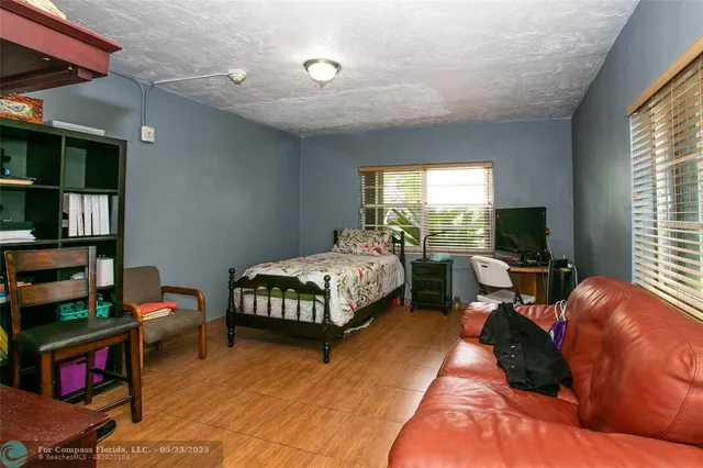 a bedroom with a bed a bookshelf and a window