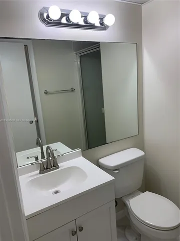 a bathroom with a sink a toilet a mirror and vanity