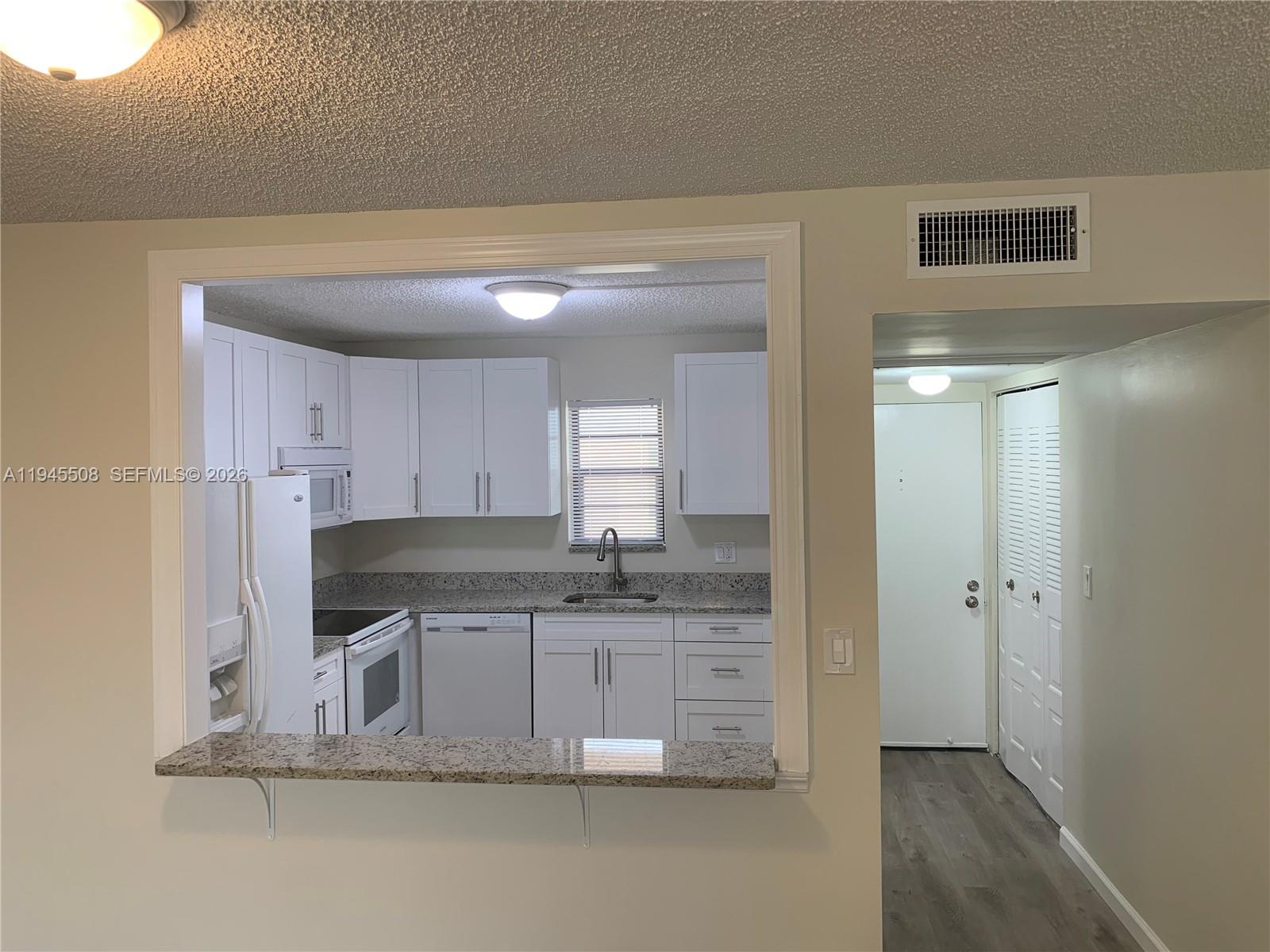 9273 Southwest 8th Street, Unit 411 Boca Raton, FL 33428 - Photo 3 of 21 a kitchen with stainless steel appliances granite countertop a sink and cabinets