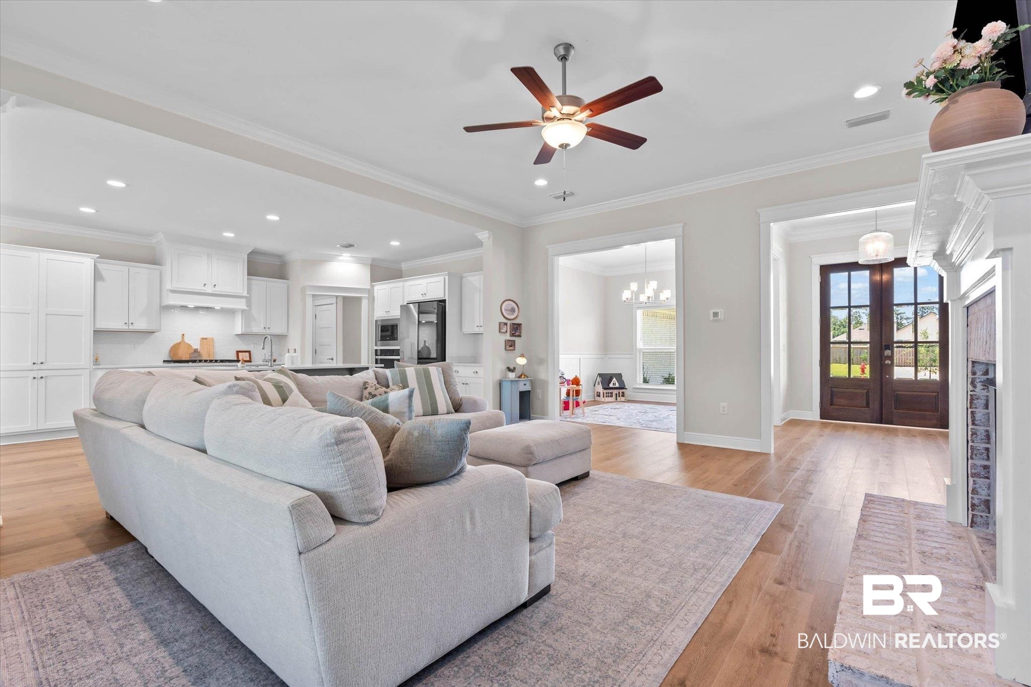 23523 Travis Stock Street Foley, AL 36535 - Photo 7 of 45 Open-concept living space featuring wood-finish flooring, recessed lighting, a ceiling fan, and a painted brick fireplace surround