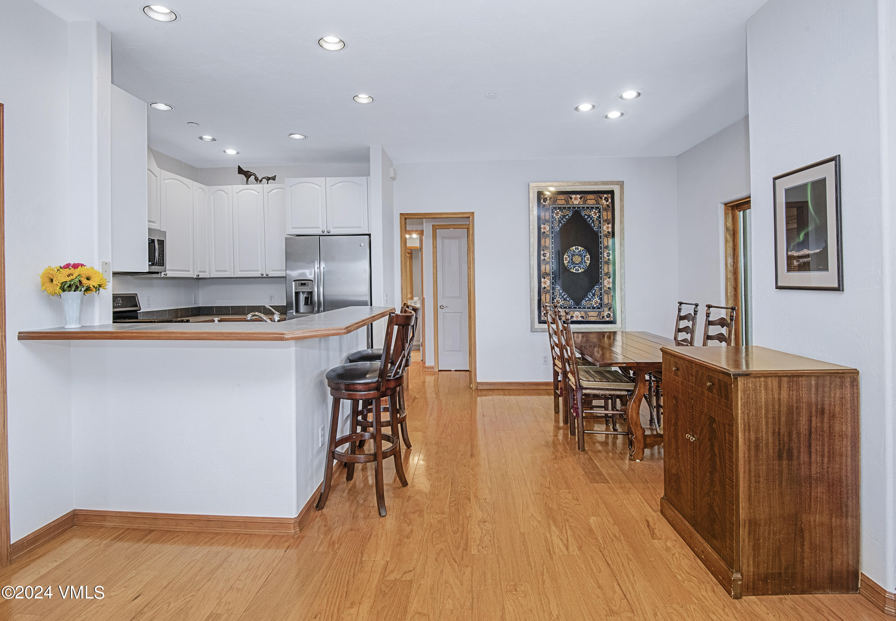 751 Singletree Road, Unit 3N Edwards, CO 81632 - Photo 15 of 35 a kitchen with stainless steel appliances granite countertop a refrigerator a stove a sink a dining table and chairs with wooden floor