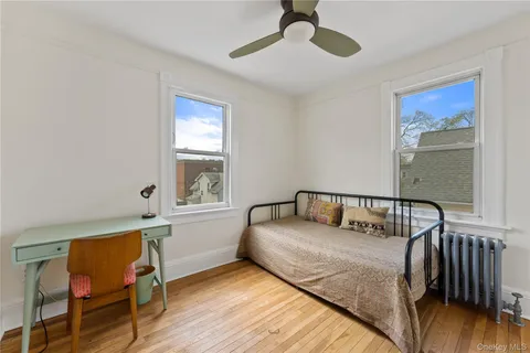 a bedroom with a bed window and chair