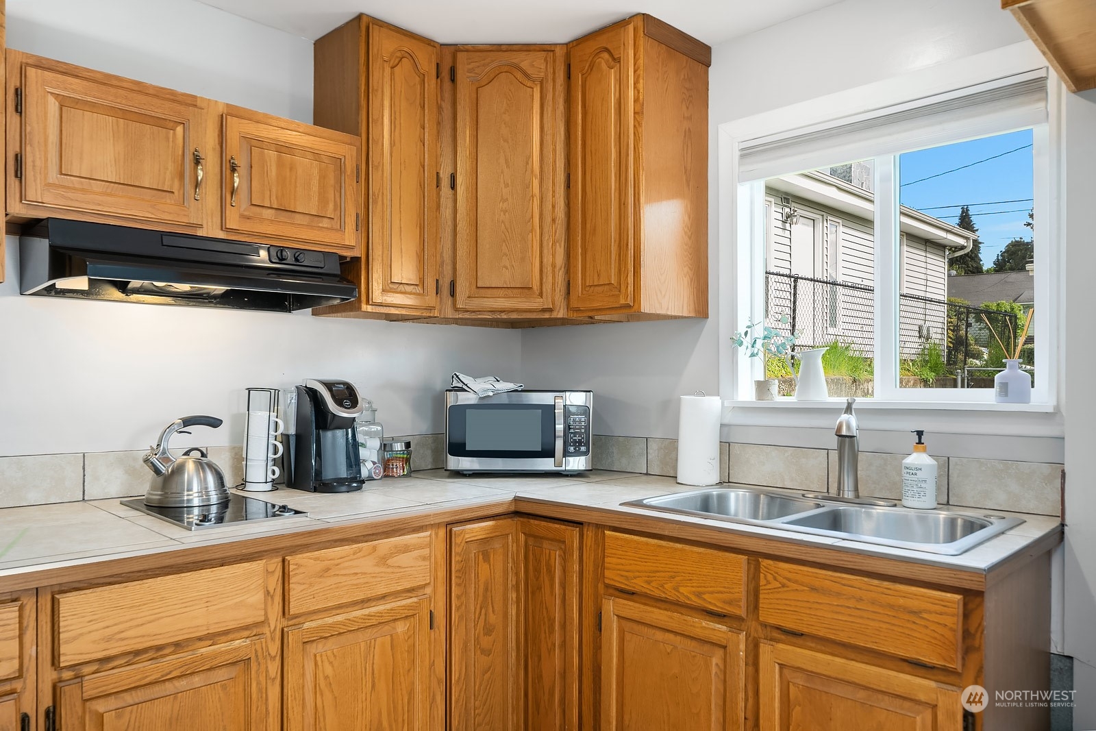 1202 North 29th Street Renton, WA 98056 - Photo 23 of 35 a kitchen with stainless steel appliances granite countertop a sink a refrigerator and cabinets