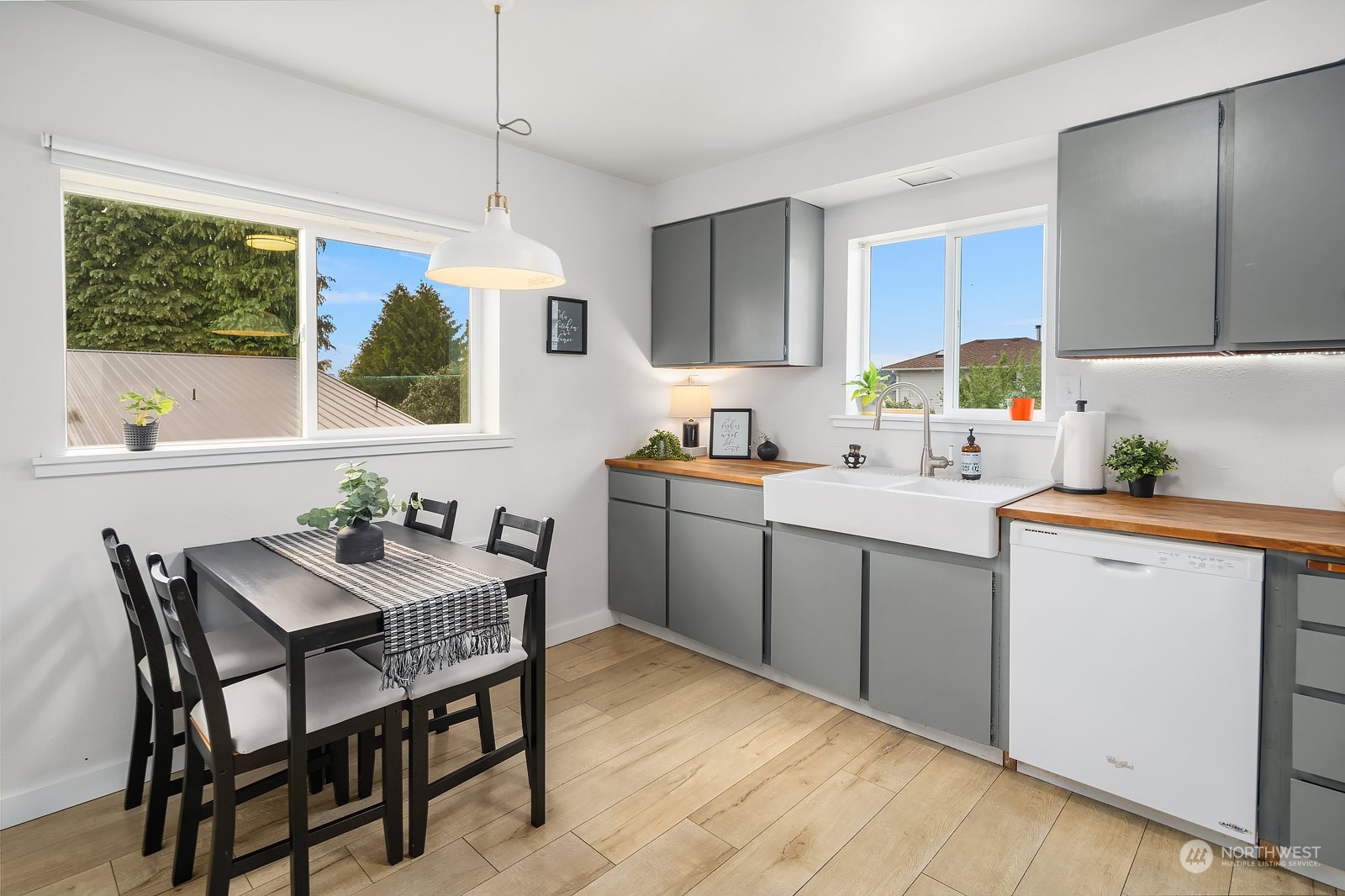1202 North 29th Street Renton, WA 98056 - Photo 7 of 35 a kitchen with a dining table chairs and white cabinets