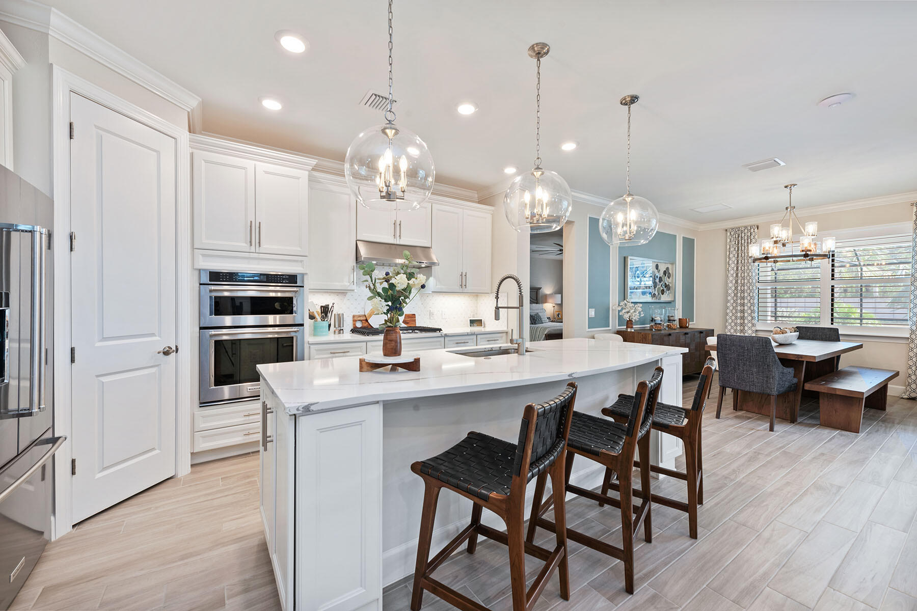 2714 Aviamar Circle Naples, FL 34114 - Photo 8 of 53 a kitchen with kitchen island a dining table chairs and cabinets