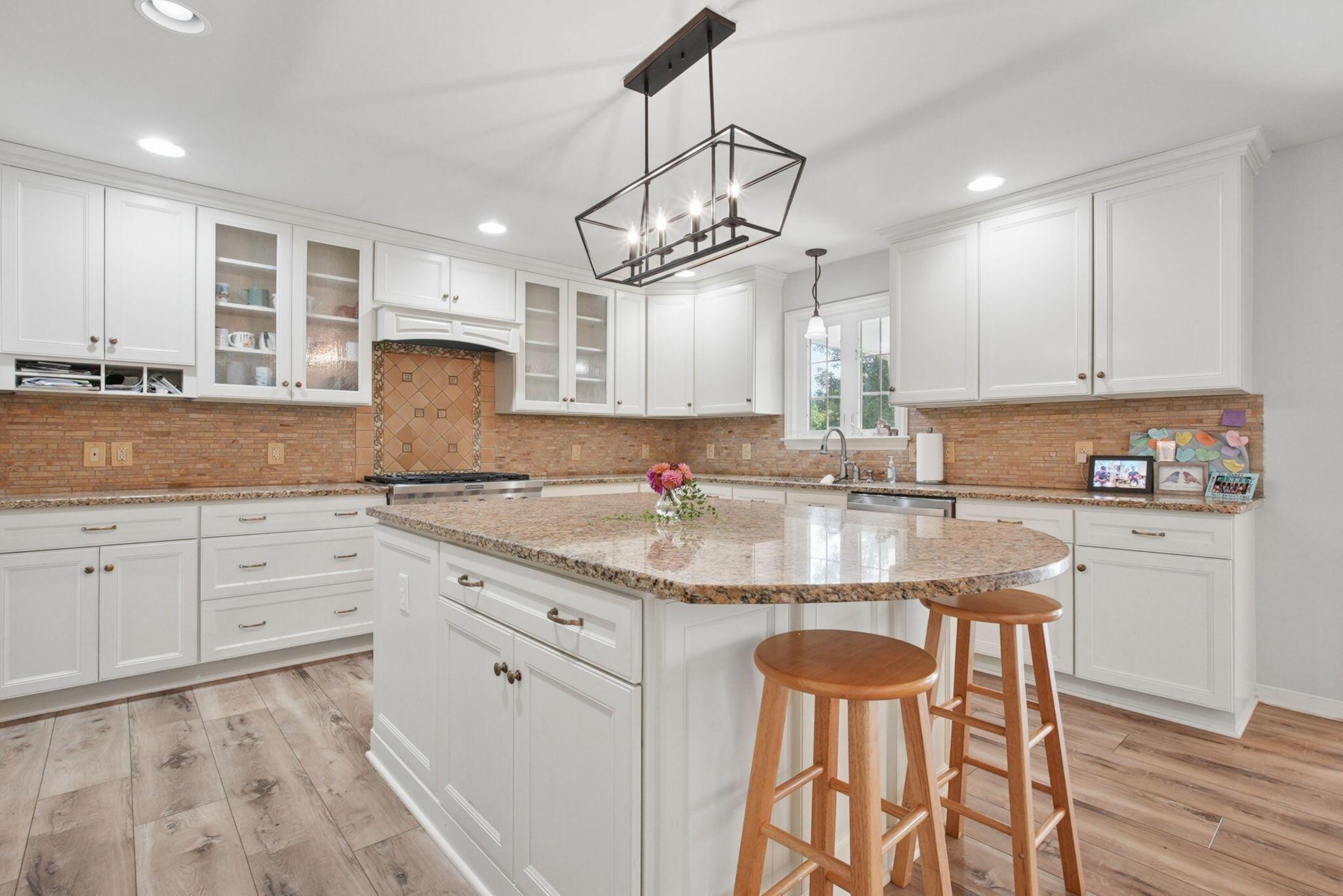 9435 Concord Road Powell, OH 43065 - Photo 22 of 77 Kitchen featuring white cabinetry, granite countertops, wood-finish flooring, a central island, and recessed lighting