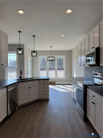 a large kitchen with cabinets wooden floor and stainless steel appliances