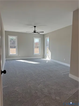 an empty room with windows and ceiling fan