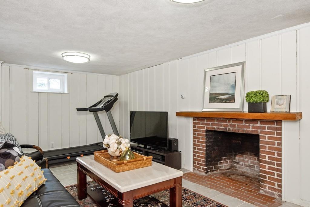 104 Bertwell Road Lexington, MA 02420 - Photo 27 of 32 a living room with furniture a flat screen tv and a fireplace