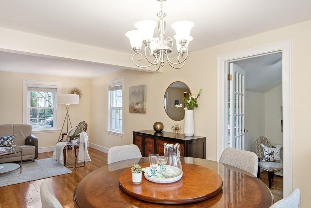 104 Bertwell Road Lexington, MA 02420 - Photo 8 of 32 a dining room with wooden floor a chandelier a wooden table and chairs