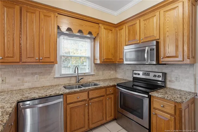 a kitchen with stainless steel appliances granite countertop a stove a sink and a microwave