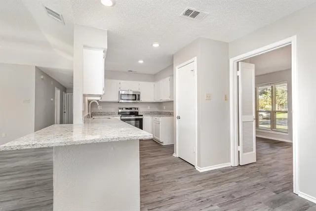 a kitchen with stainless steel appliances granite countertop a refrigerator and a sink