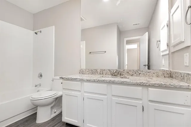 a bathroom with a granite countertop sink toilet a large mirror and shower