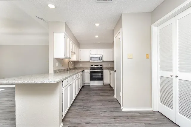a large kitchen with stainless steel appliances granite countertop a stove and a sink