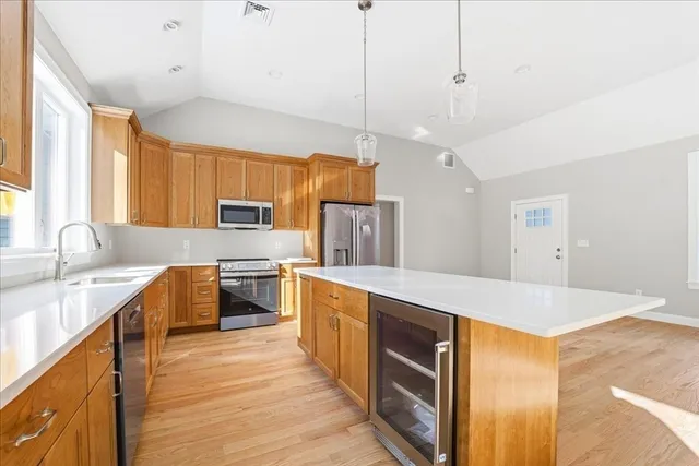 a large kitchen with stainless steel appliances granite countertop a sink a stove counter space and cabinets